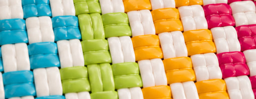 Close-up of the Tropical Punch Gala Bag -woven mat with colorful squares in blue, green, orange, and pink.